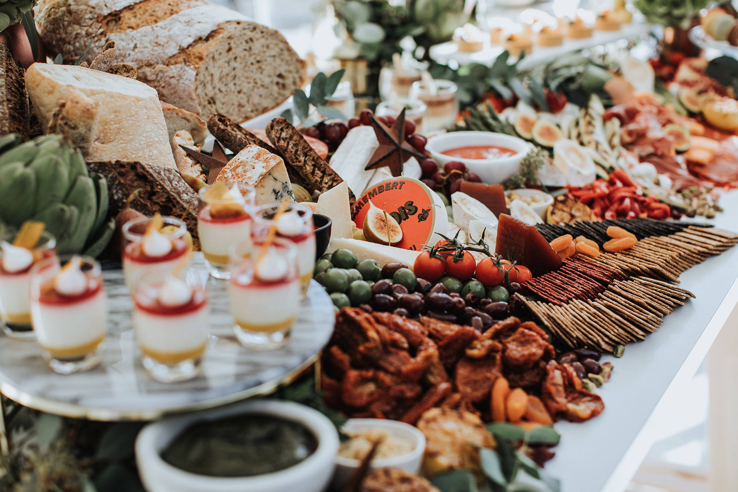 A grazing table in full spread, cheeses and charcuterie and fruit