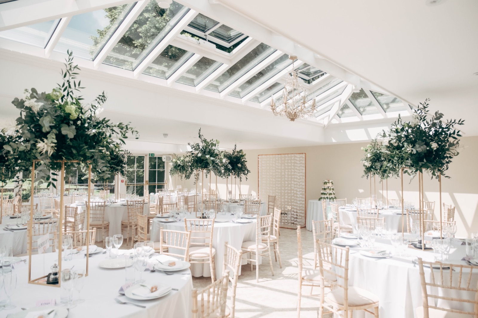 Wedding tables beneath the glass roof of the Orangery at Hayne House
