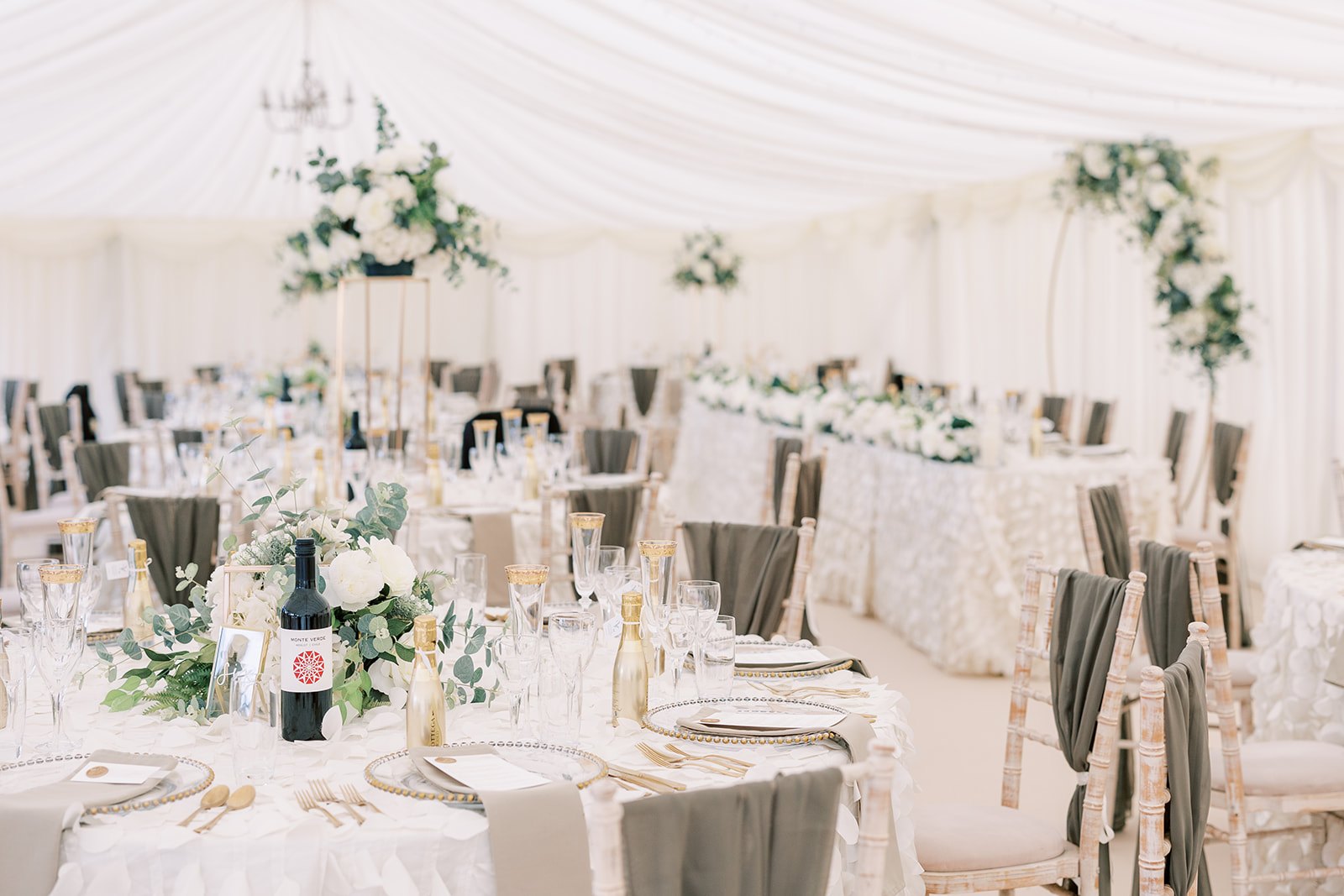 White flowers and candlelit tables prepared for a marquee wedding