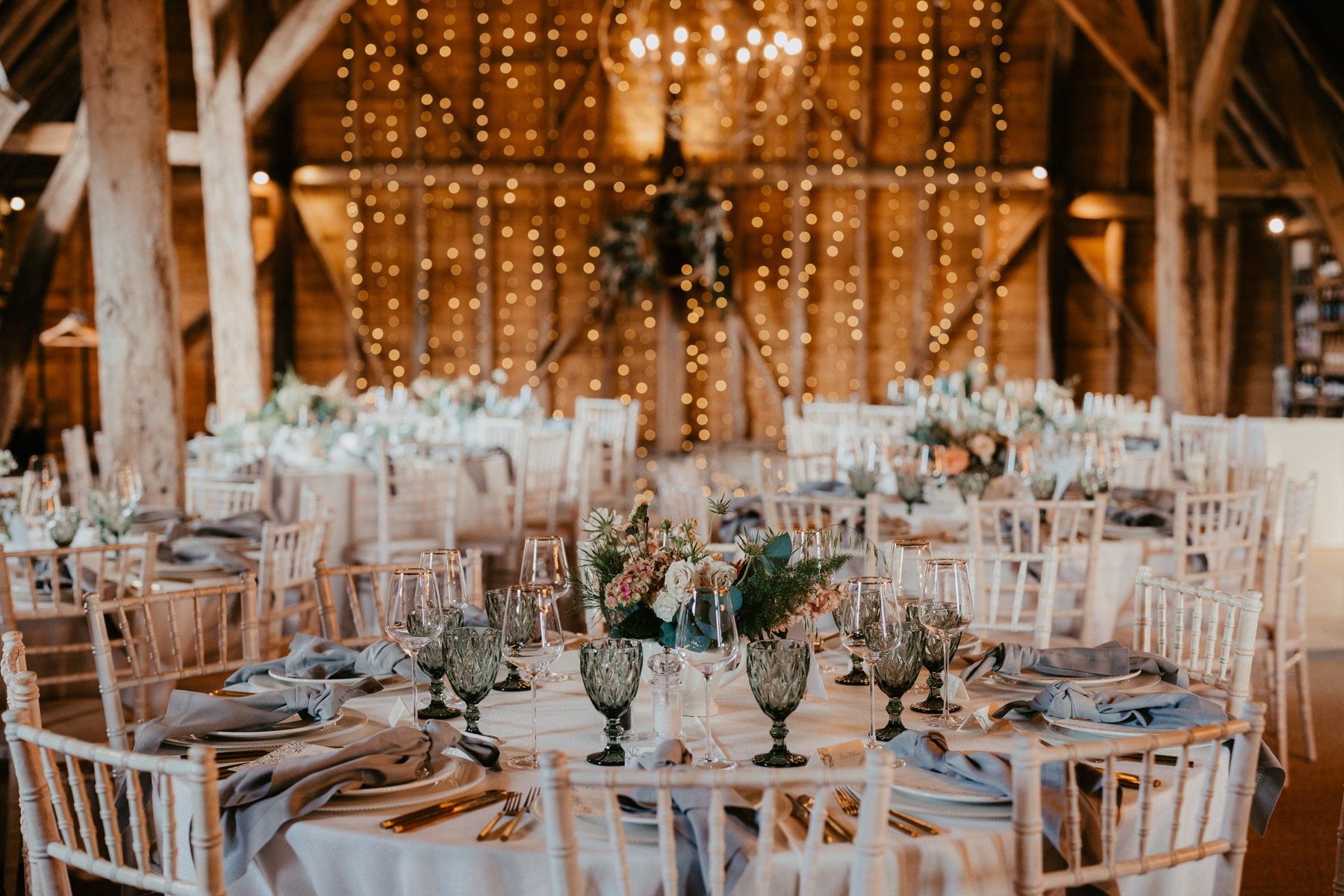 Wedding tables beneath the barn chandeliers at Odo’s Barn