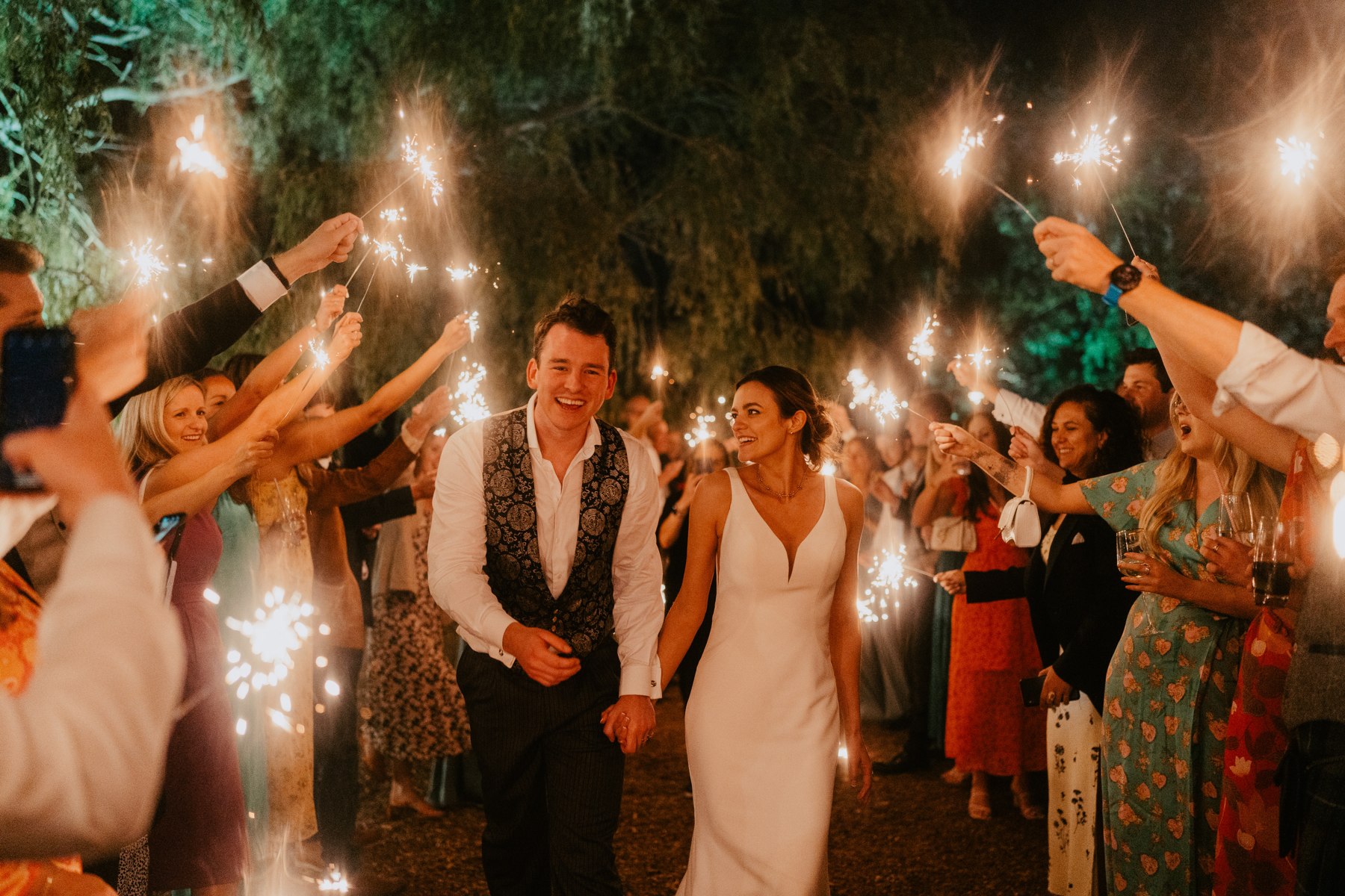 A couple celebrating with sparklers at Odo’s Barn