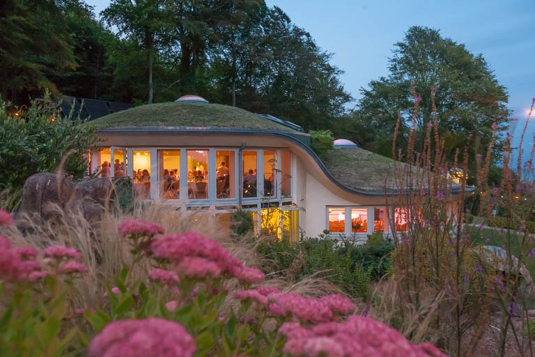 The curved venue illuminated in the evening at The Pines Calyx