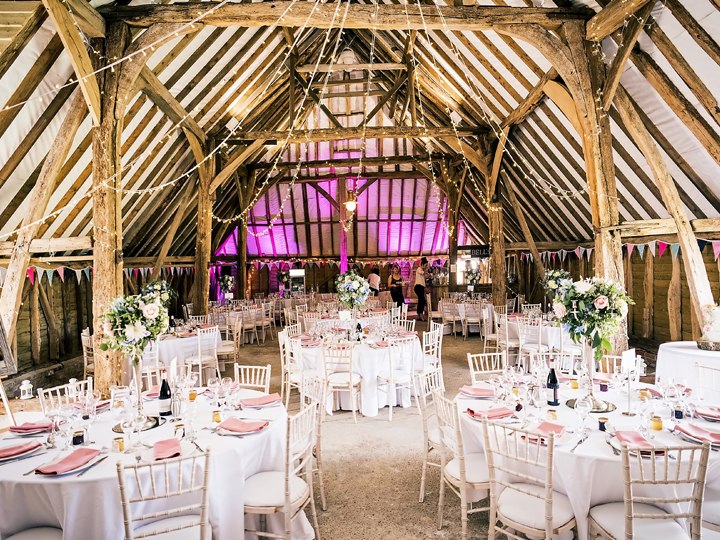 Wedding tables beneath the timber beams at Ruffynes Barn