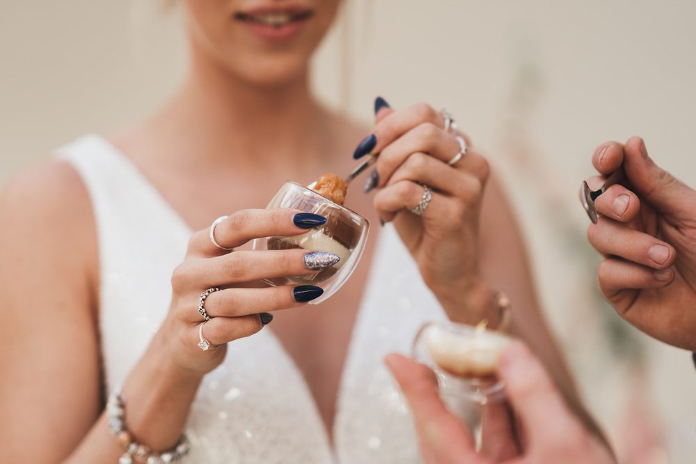 The bride, canapé in hand, mid-story