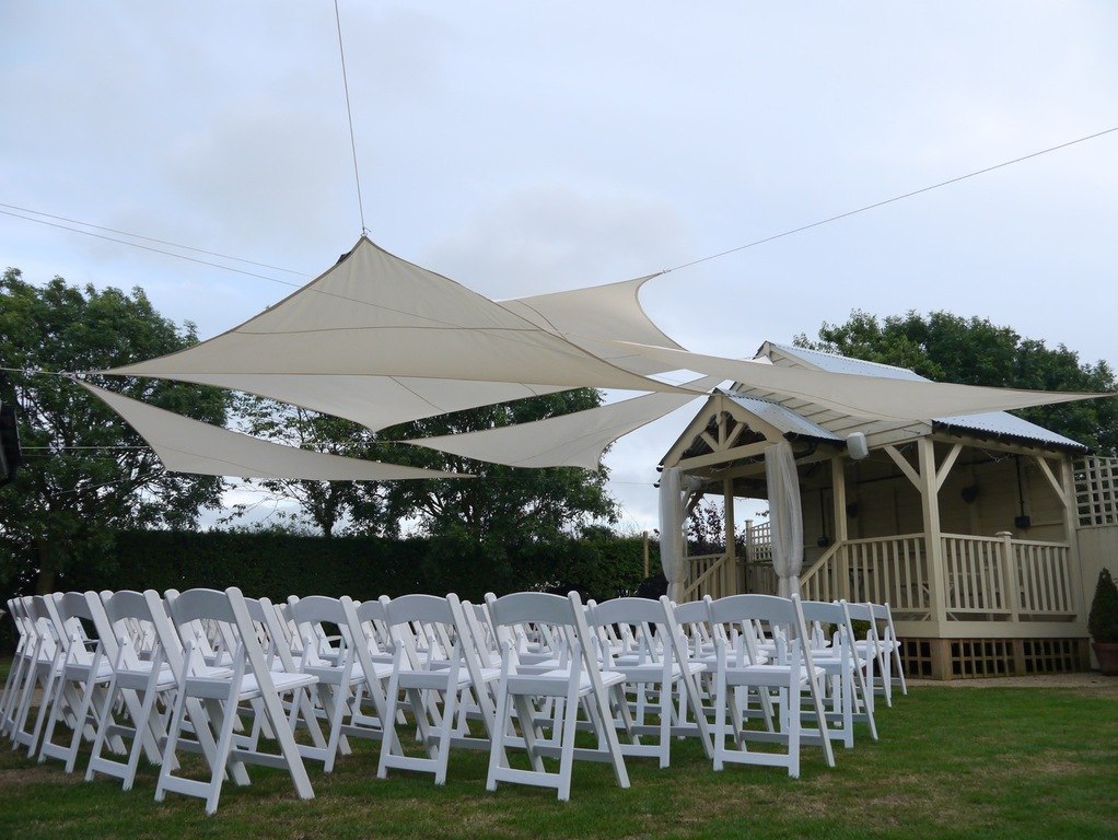 An outdoor ceremony beneath a canopy at The Red Barn
