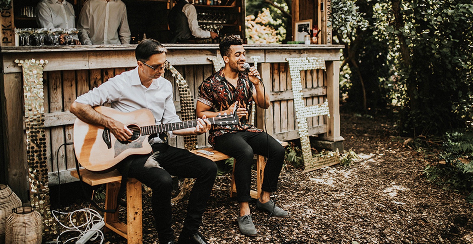 Musicians performing beside a rustic outdoor bar at Wilderness