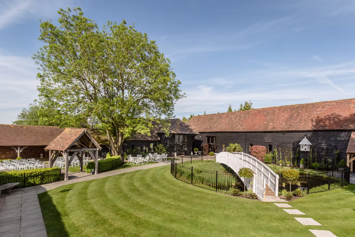 The black weatherboard barns, garden and white bridge at Winters Barns