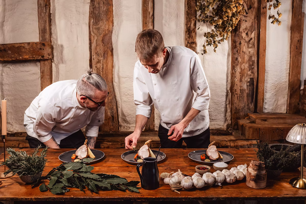 Two Anderson’s chefs carefully plating food together