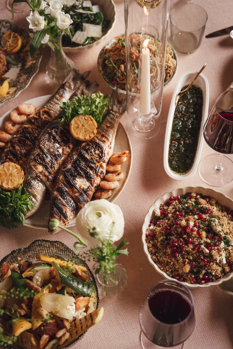 A feast of sharing dishes laid along a dining table