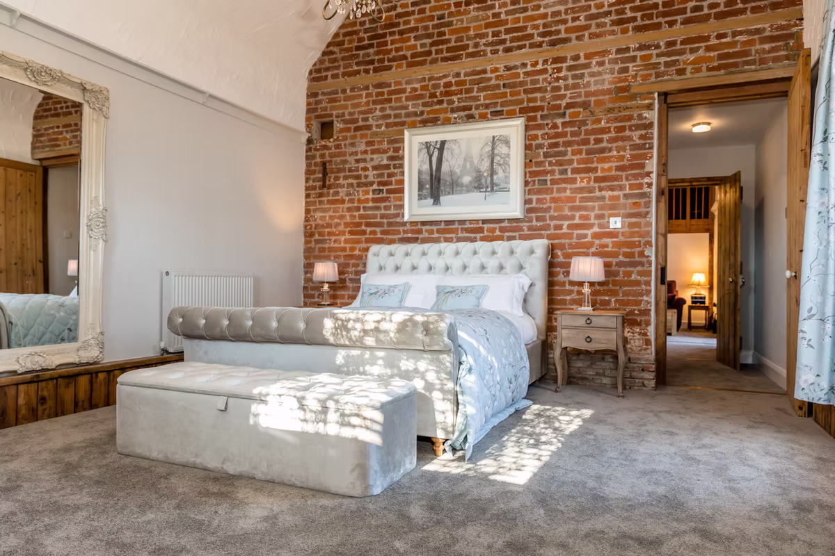 The cottage bedroom with an exposed brick wall at Winters Barns