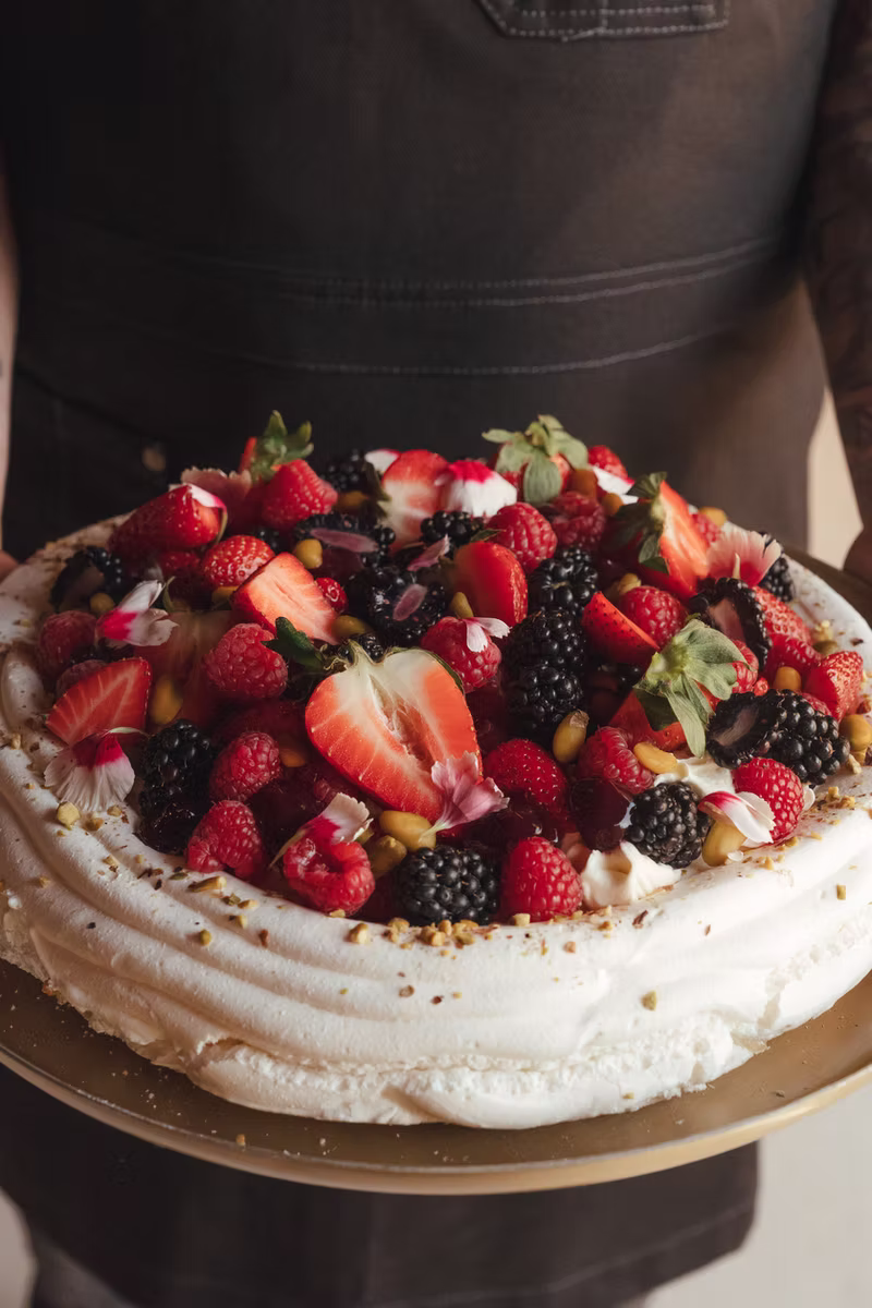 A berry pavlova piled with strawberries and raspberries