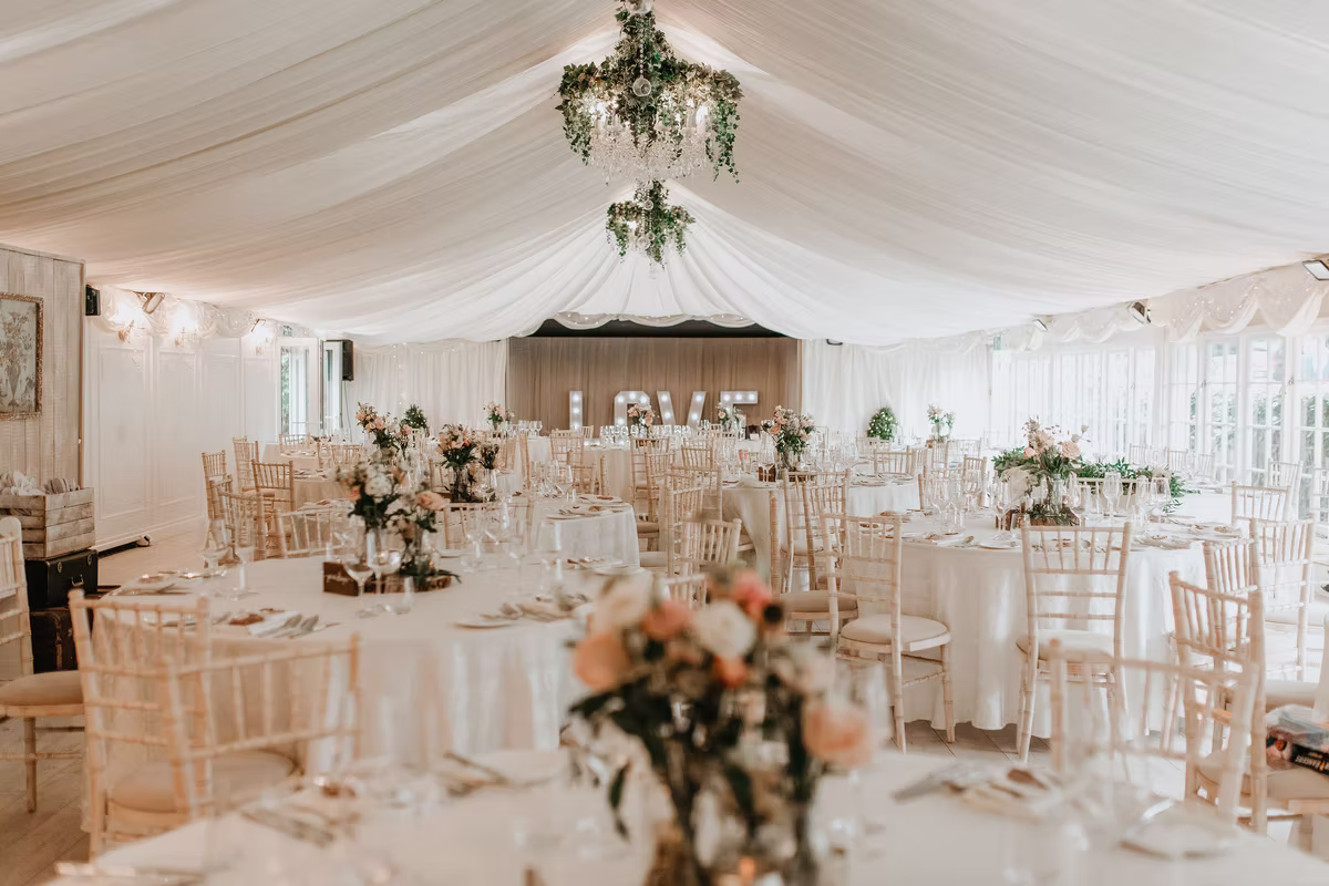 Tables and floral decorations inside the wedding marquee at Marleybrook House