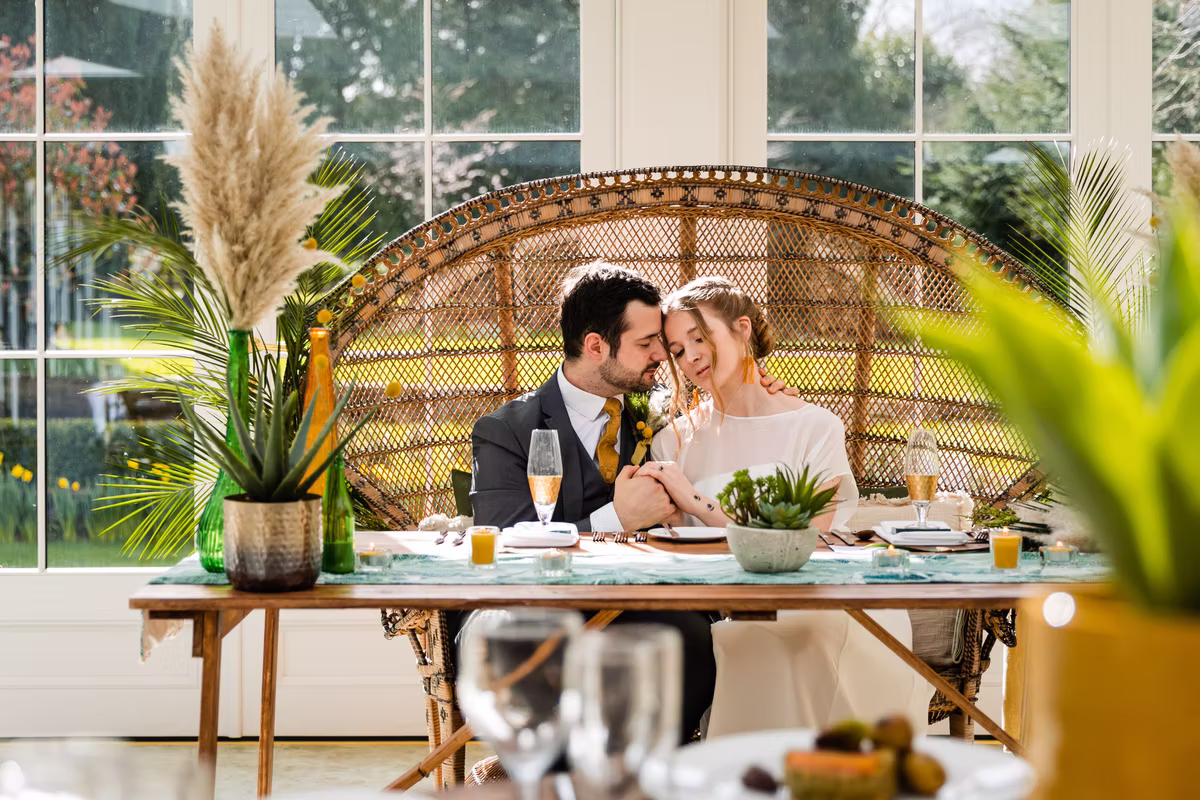 A couple at a table framed by greenery at the Hayne House sustainability styled shoot