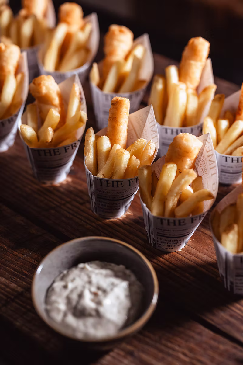 Fish and chips served in individual paper cones with tartare sauce